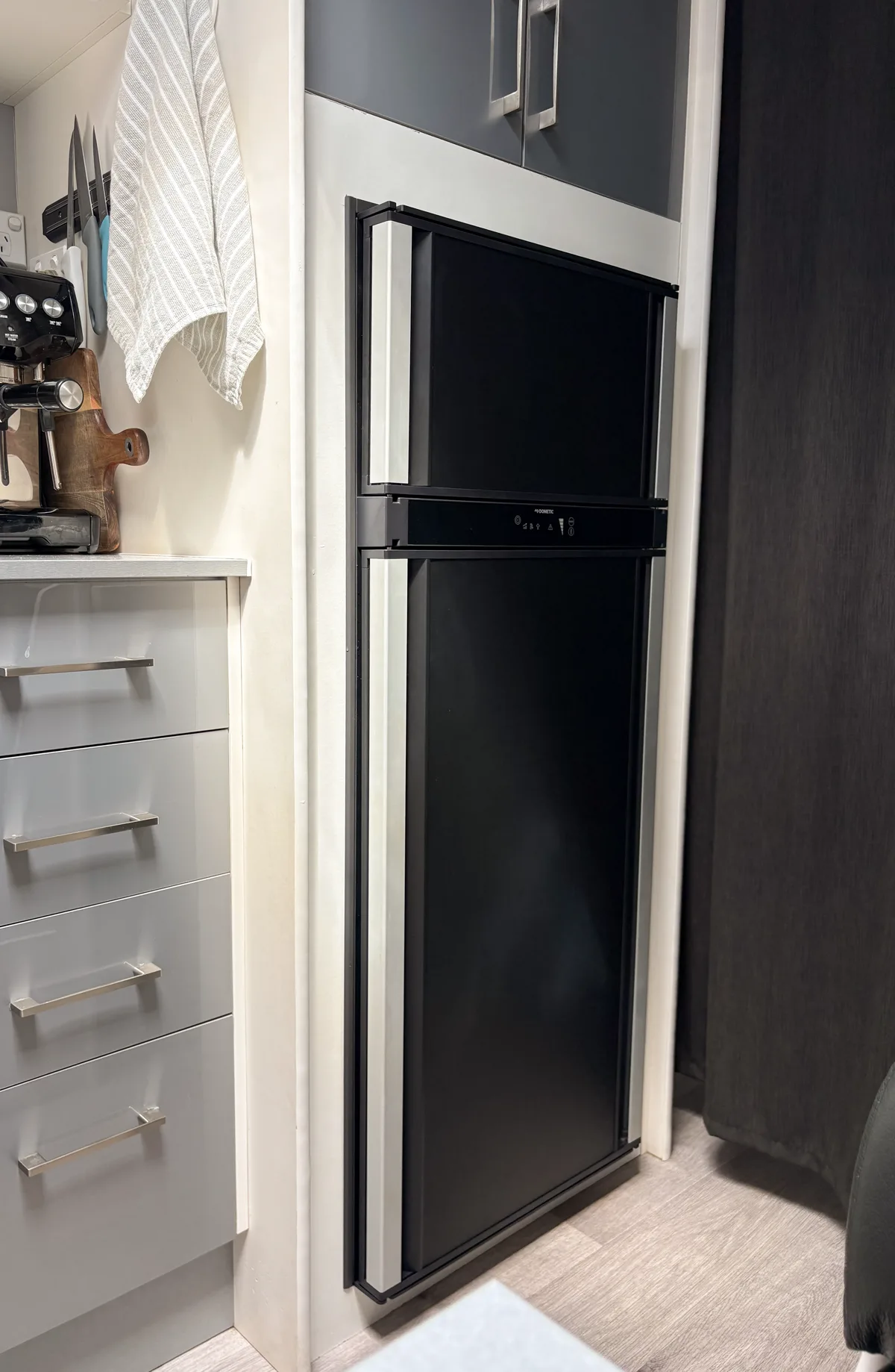 The Dometic 200L 12V fridge fitted into the caravan cabinetry beside the kitchen drawers